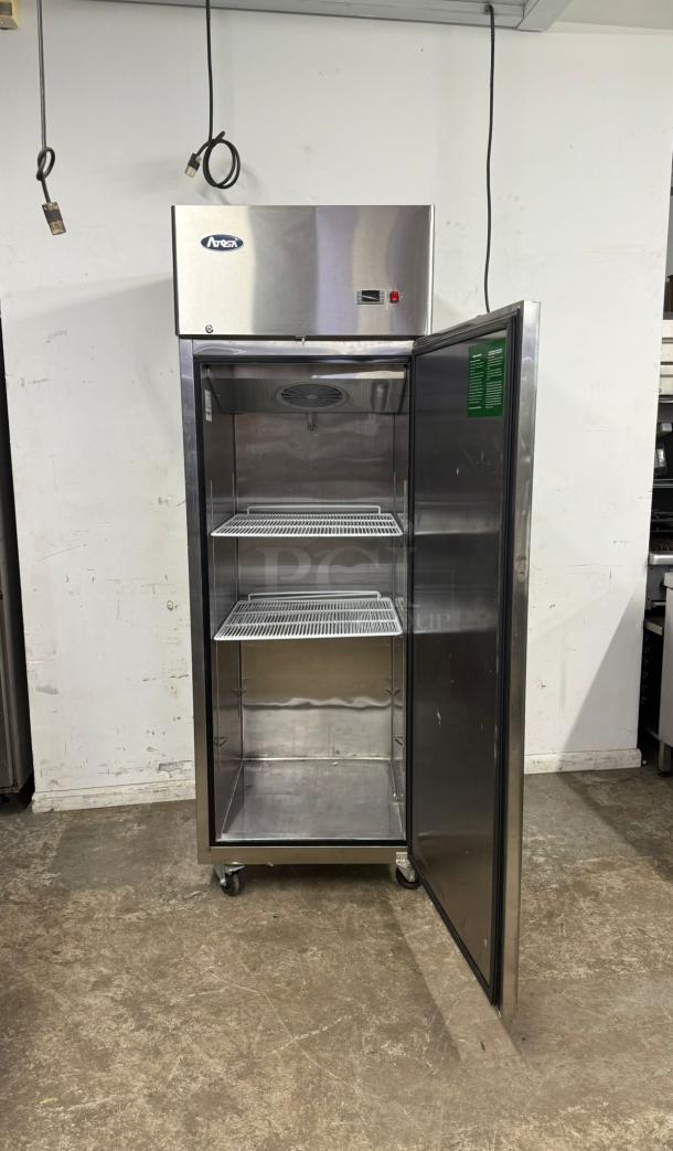 Atosa MBF8001 22.6 Cu.ft single door top mount reach-in freezer, stainless steel, open door, two wire shelves, on casters.