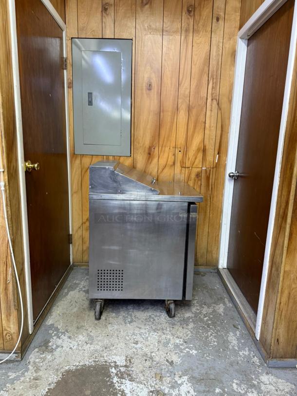 True TSSU-27-08-HC sandwich prep table, 27 7/8", right-hinged door, stainless steel, on casters, in fair condition.