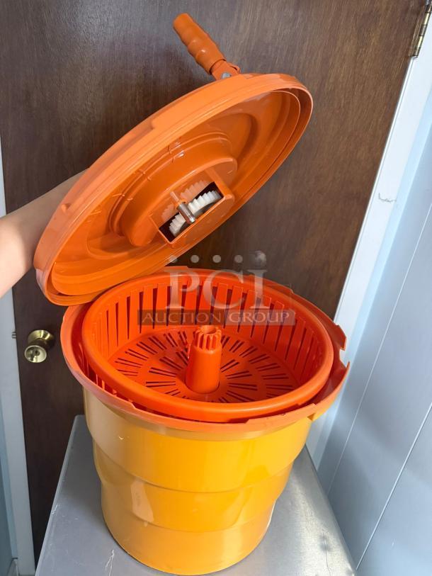 Dynamic manual salad spinner, vibrant orange, featuring a hand crank and internal basket. Excellent condition, dries lettuce efficiently.