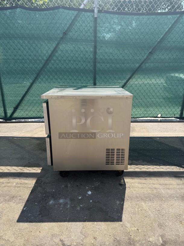 Commercial stainless steel 2-drawer undercounter refrigerator, good condition, with ventilated side panel and PCI Auction Group marking.