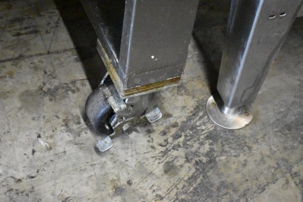 Commercial caster wheel of a Baxter BV400G stainless steel rotating rack oven, showing sturdy metal construction.