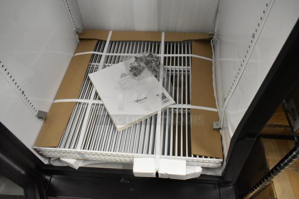 Brand new True GDM-23-HC commercial cooler with poly-coated racks, 115 volts, 1 phase, minor scratches and dents visible.