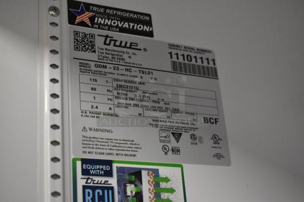Brand new 2025 True GDM-23-HC commercial cooler tag, showing model, 115V, 1 phase, and poly coated racks specs.