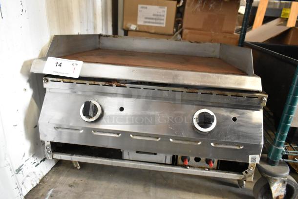 Stainless steel commercial countertop gas griddle with dual knobs. Visible wear and rust. Includes auction tag labeled "14."
