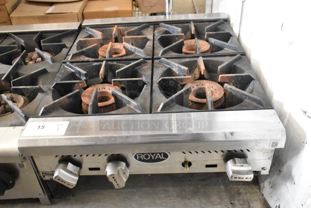 Royal stainless steel commercial 4-burner gas range, well-used condition, prominent control knobs, and Royal branding.
