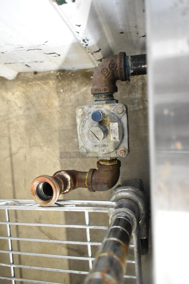 Gas connection detail of a Royal Stainless Steel Commercial Countertop Gas Powered 4 Burner Range; visible wear and rust.