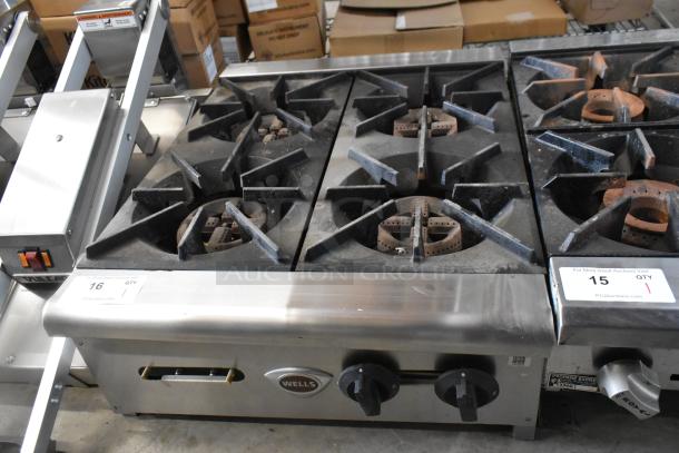 Wells stainless steel commercial 4-burner gas range, countertop model, used condition, visible control knobs.