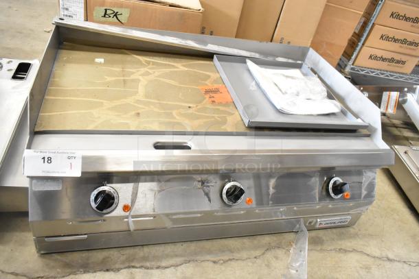Brand new Garland 2151197 stainless steel commercial countertop flat top griddle, featuring control knobs, packaged accessories, and visible branding label.