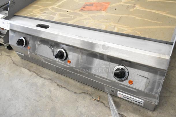 Brand new Garland 2151197 stainless steel commercial countertop flat top griddle with control knobs, protective wrapping, and logo.