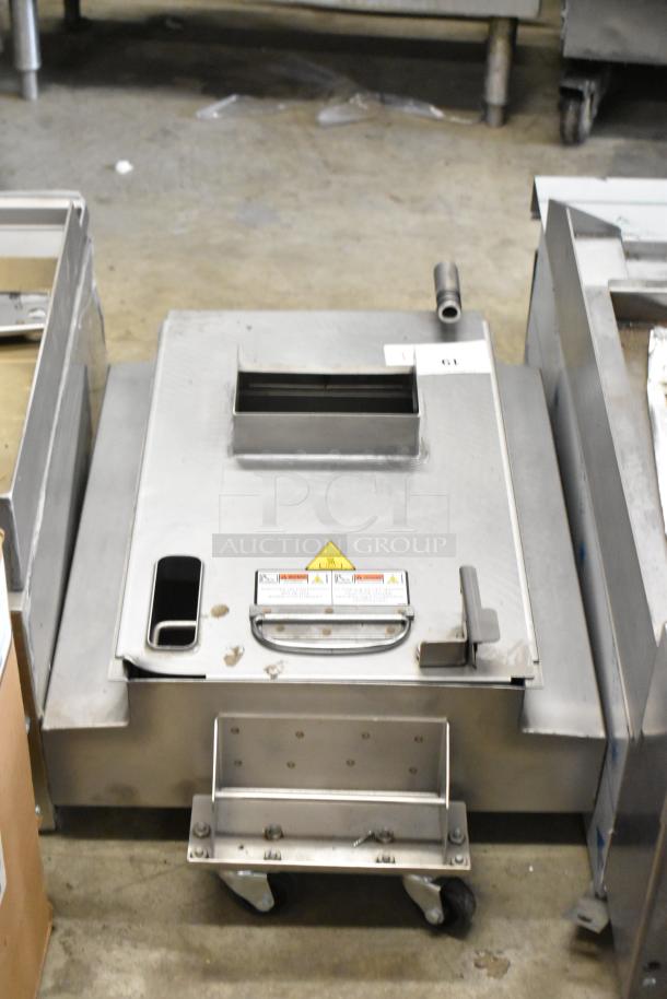 Metal commercial grease trap on casters, features handle, warning labels, and access panel. Used condition.