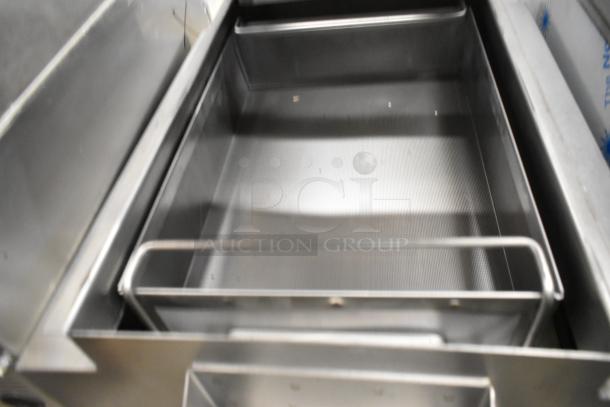 Metal commercial grease trap on commercial casters, stainless steel, high capacity, pristine condition, ideal for kitchens.