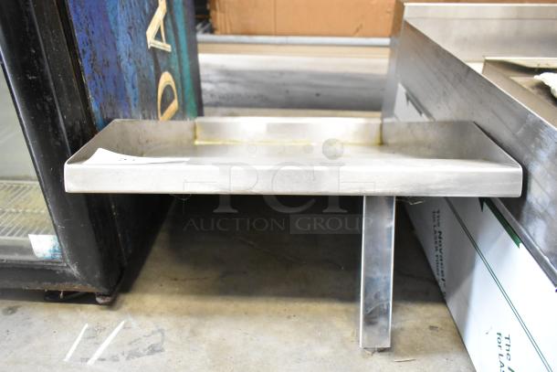 Stainless steel flat top griddle plate, slightly used, with raised sides and sturdy metal legs. Perfect for commercial kitchens.