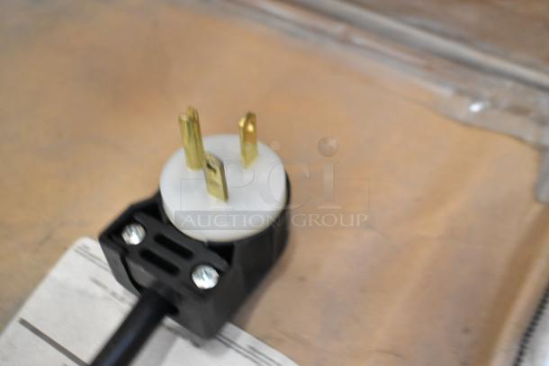 Close-up of a power plug for the APW Wyott M-95-2 bun toaster, showing three gold prongs.