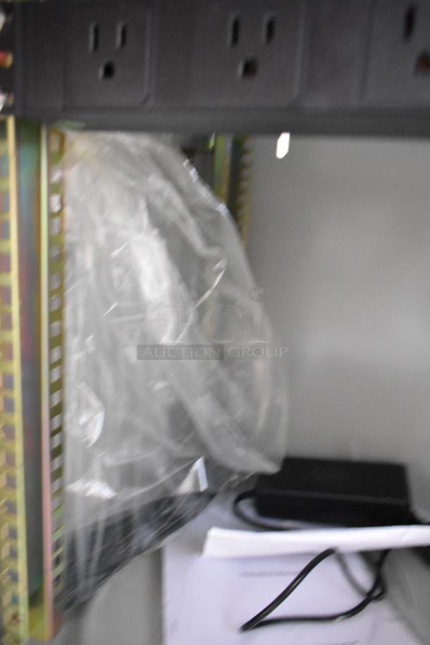 Brand new BlackShields DC0300 white metal cabinet interior, showing power outlets and packaged components.