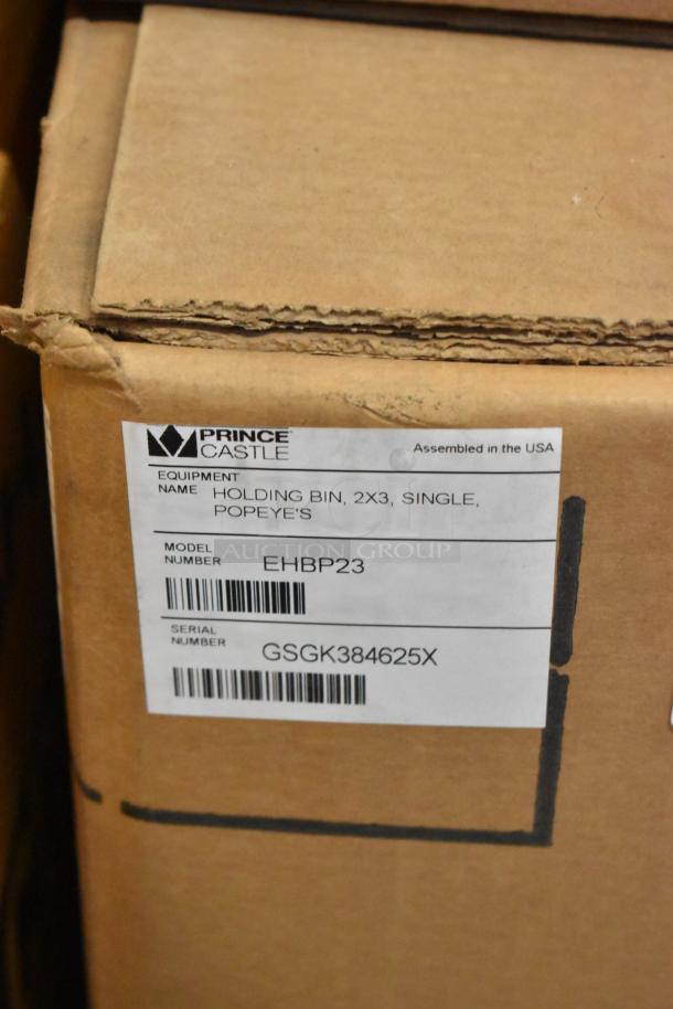 Brand new Prince Castle EHBP23 stainless steel holding merchandiser in box, 120V, 1 phase; model and serial labels visible.