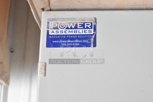 Brand new Power Assemblies gray metal box, labeled "Innovative Power Solution," includes contact info and website.