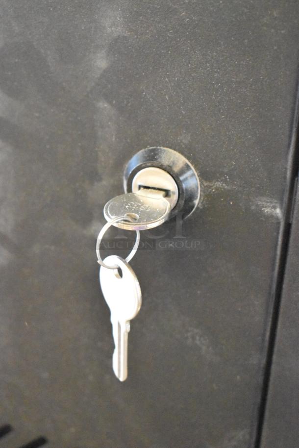 Brand new black metal enclosure system with key in lock. Rugged finish, secure locking mechanism visible.