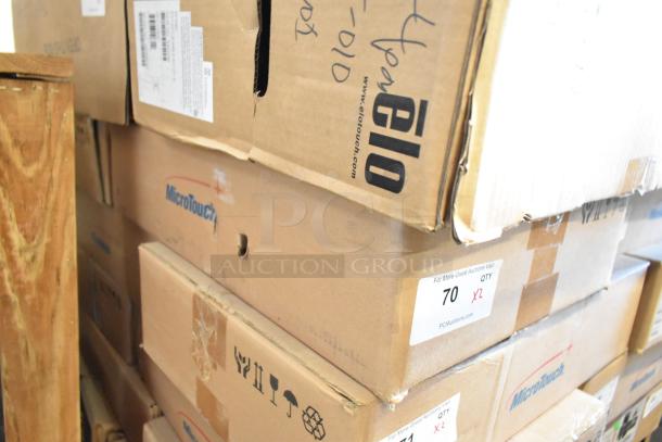 Stack of new MicroTouch IC-215P-AA2 monitors in boxes, labeled 2X your bid, showing logo and auction label.