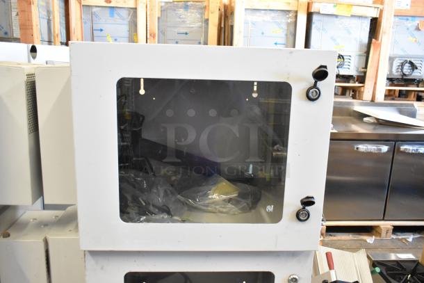 Brand new BlackShields DC0300 white metal cabinet with clear front panel, locking mechanism, and protective interior wrap.