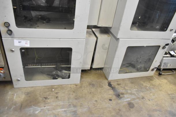 Two BlackShields DC0300 white metal cabinets, brand new, one missing key, visible storage contents, auction tag visible.