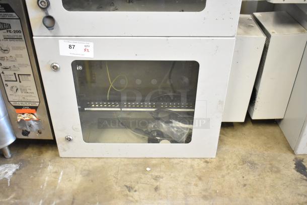 2 new BlackShields DC0300 white metal cabinets, visible glass panels, 1 missing key, auction lot tag, condition unclear.