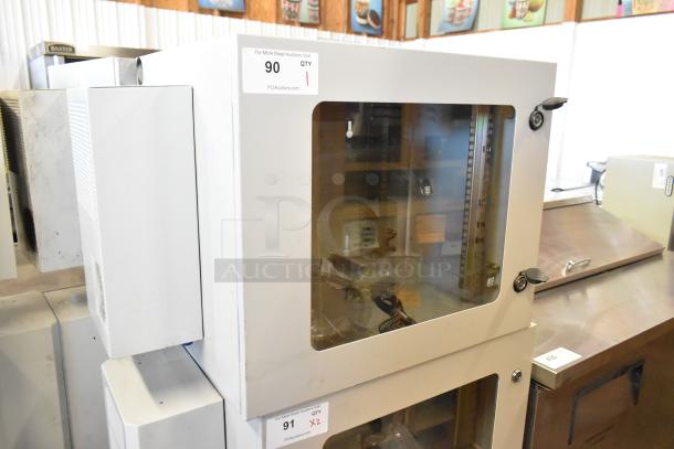 BRAND NEW BlackShields DC0300 white metal cabinet with glass door, visible interior shelving, auction label, and pristine condition.