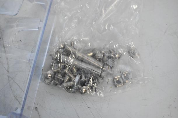 Lot of brand new hardware pieces, including a pipe mounting kit and outlet box cover, sealed in plastic packaging.