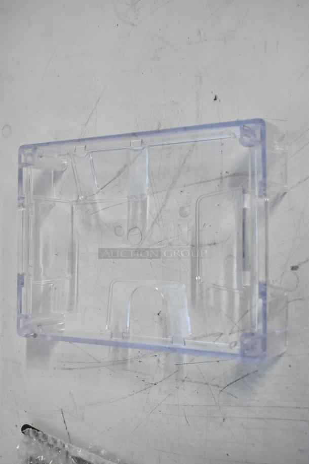 Brand new outlet box cover, transparent plastic, includes mounting kit. New condition, ideal for electrical installations.