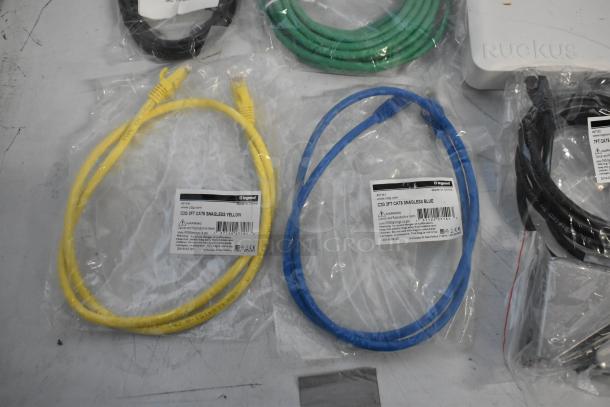 Lot includes Cradle Point AER2200, Ruckus Access Point, and assorted wiring. New in packaging, features network cables.