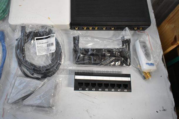 Brand new lot including Cradle Point AER2200, Ruckus Access Point, wiring, and connectors in original packaging.