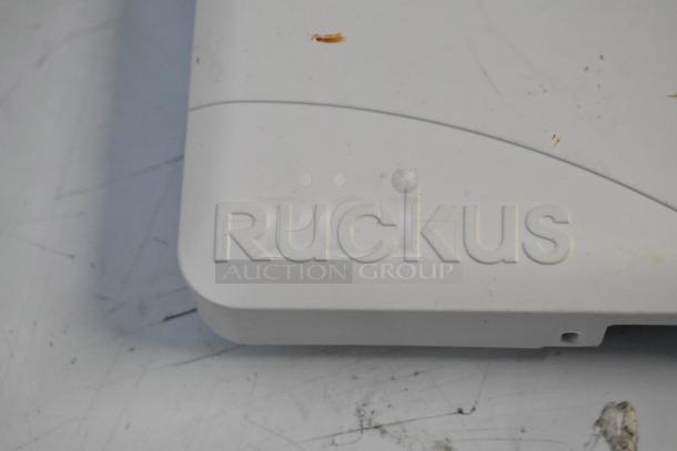 Ruckus access point close-up, brand name visible. Part of a new lot including Cradle Point AER2200 and wiring.