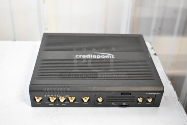 Alt text: Cradlepoint AER2200 unit, brand new, with various ports and label markings on front, included in auction lot.