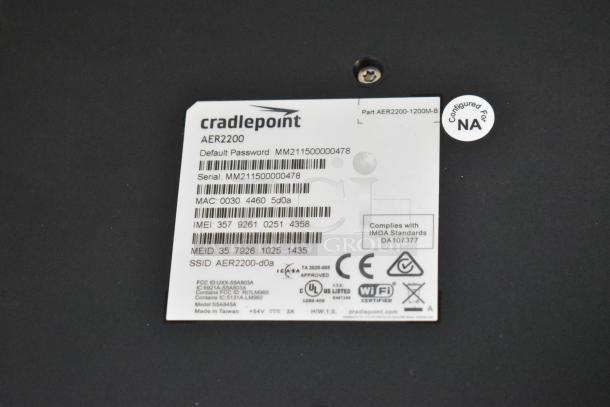 Cradlepoint AER2200 unit label showing model, serial number, and compliance marks; part of a new lot including Ruckus access point.