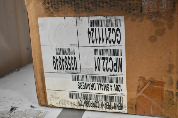 Brand new Henny Penny MPC-22 stainless steel holding bin in box. 120V, 1 phase. Box label showing product info and serial numbers.