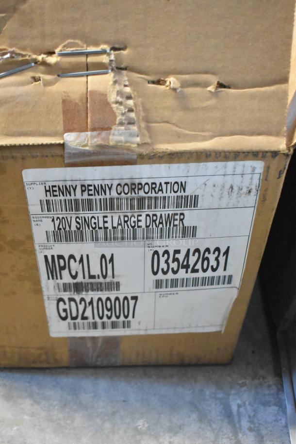 Brand new Henny Penny MPC-1L stainless steel holding bin in box. Features 110V, 1 phase. Label shows model number and details.