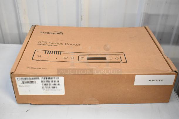 Cardboard box containing Cradlepoint AER Series Router, model AER2200, with visible barcodes and label for identification.