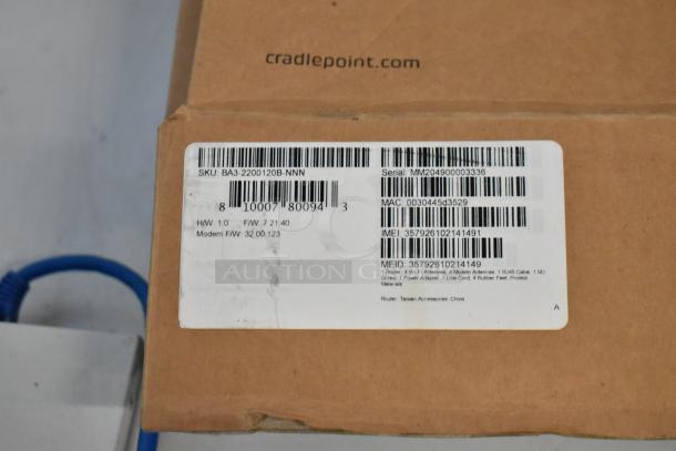 Cardboard box labeled "cradlepoint.com" with a sticker showing SKU BA3-2200120B-NNN, serial MM204900003336, and item details.