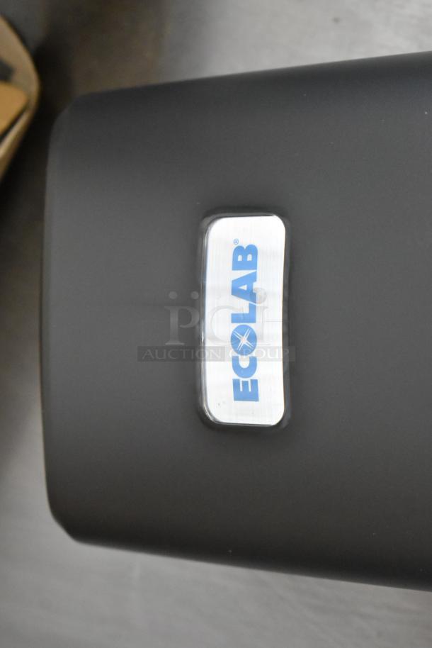 6 new Ecolab Nexa Classic Touch-Free Dispensers in box, sleek black design, prominent Ecolab logo.