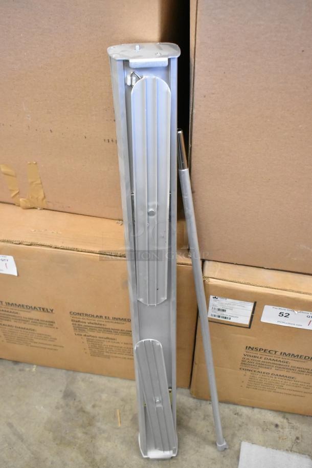 Retractable easel with aluminum legs and holders, leaning against cardboard boxes. Comes with two soft bags.