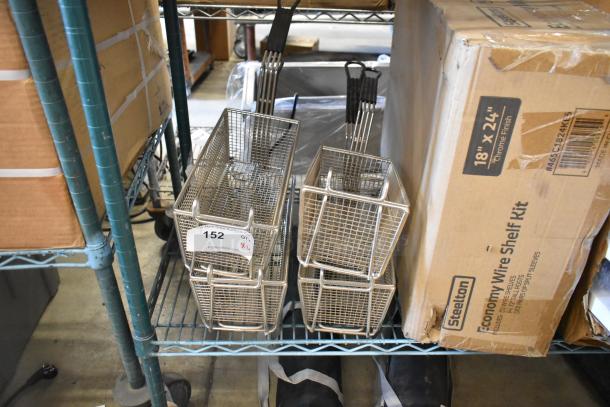 Brand new metal fry baskets, set of 4, with black handles, on a storage shelf. Auction label shows quantity 4.