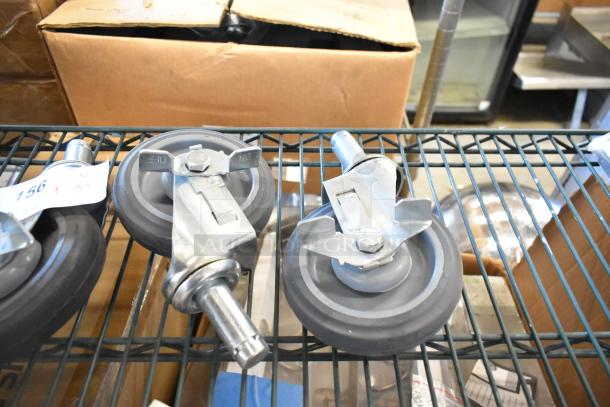 Lot of 4 commercial casters, metal and rubber, with threaded stems; suitable for industrial use. Tags indicate condition.