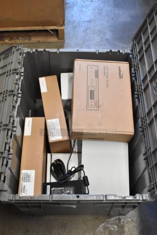 Lot of 10 brand new items including Avigilon VMA-ENVR1-8P8 and Cradlepoint. Items are boxed, located in a gray bin.