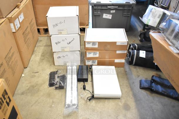 Lot of 10 brand new items including Avigilon VMA-ENVR1-8P8. Boxes labeled with Avigilon tags, placed on a warehouse floor.