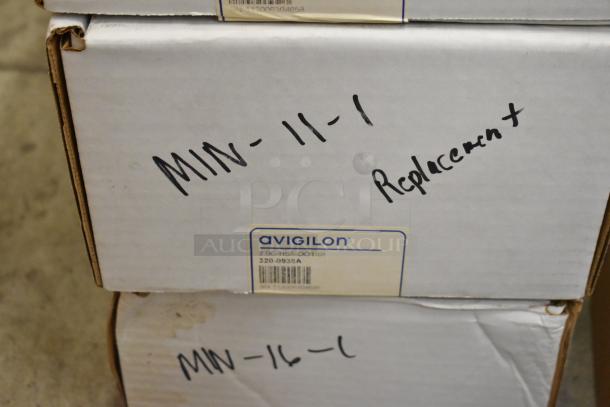 Boxes of various brand new items, including Avigilon VMA-ENVR1-8P8, labeled "Replacement" and "MIN-11-1".
