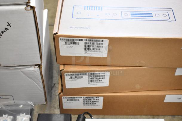 Lot of 10 brand new items, including Avigilon VMA-ENVR1-8P8 and Cradlepoint. Boxes have barcodes and item information labels.