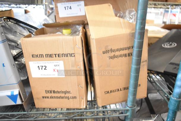 Two boxed EKM Metering EKM-PGM.75 electric meters, brand new with visible labels. Ideal for accurate energy tracking.