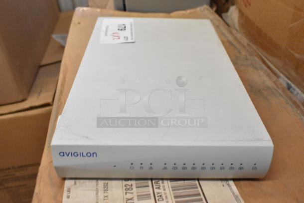 Brand new Avigilon Embedded NVR in box. Features visible ports. Includes Cradlepoint AER2200 Router.