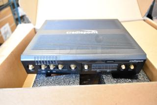 Brand new Cradlepoint AER Series Router in box, showing multiple connection ports and labels, pristine condition.