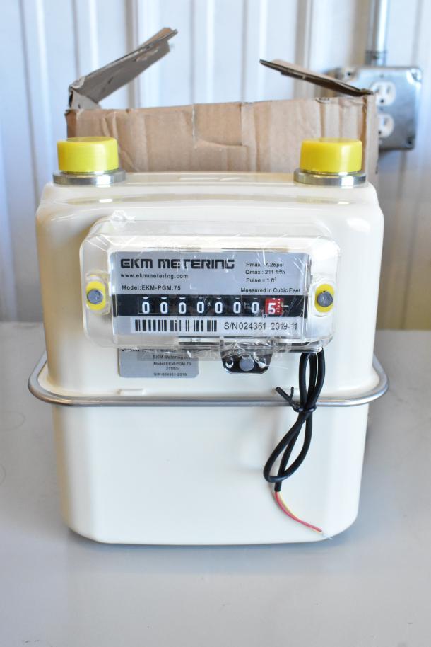 Brand new EKM Metering EKM-PGM.75 electric meter in box. Features model details, serial numbers, and packaging.