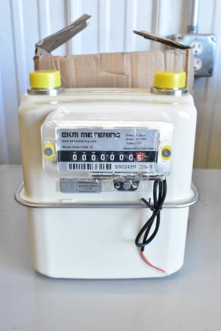 Brand new EKM Metering EKM-PGM.75 electric meter in box. Features model details, serial numbers, and packaging.